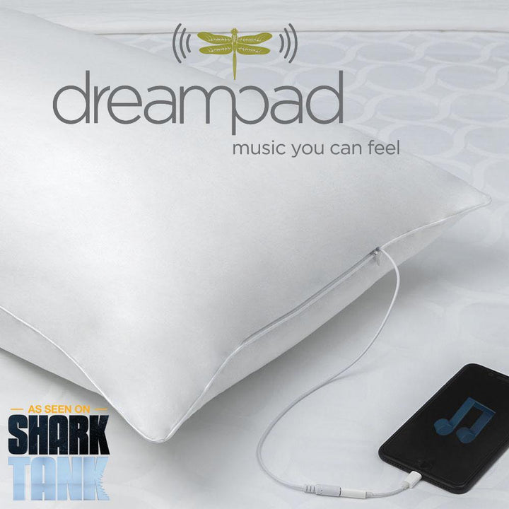 Dreampad pillow on bed with audio cable connected to phone