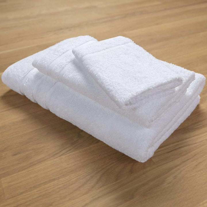 Bath towel, hand towel, and washcloth stacked on wood table