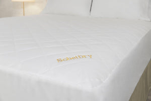 Princess Mattress Pad covering bed showing large view of bed from corner with gold SobelDry logo